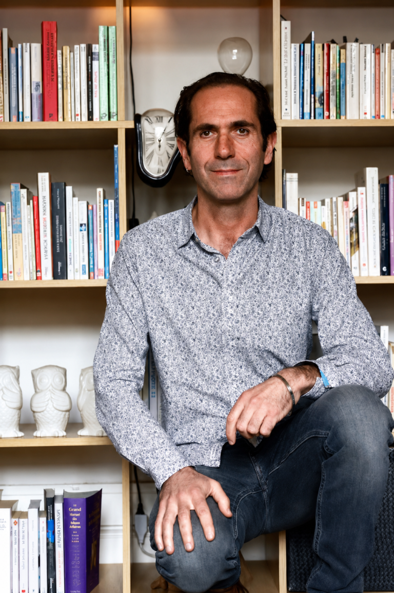 Phillipe blazquez ce tenant devant une bibliothèque